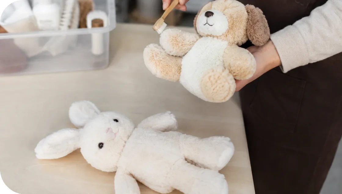 ぬいぐるみをブラシで手入れするスタッフ